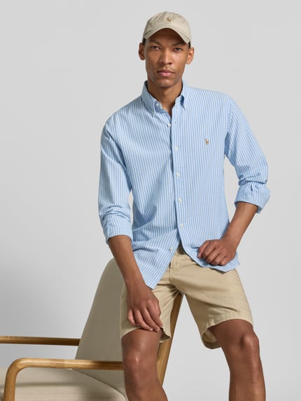 Männermodel trägt Regular Fit Freizeithemd aus reiner Baumwolle von Polo Ralph Lauren in hellblau-weiß gestreift, Ganzkörperansicht von vorne.