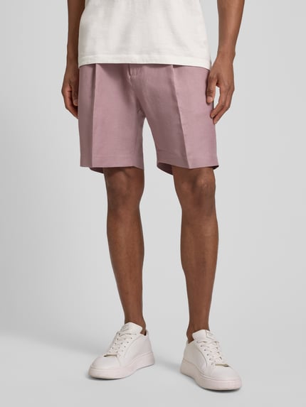 Männermodel trägt Shorts aus Leinen-Viskose-Mix Modell 'NEIL' von Antony Morato in Rosa mit Bügelfalten, Regular-Fit, elastischer Bund, Nahaufnahme Oberschenkel, Kontext: Herren Shorts, Bundweite 42 cm, Innenbeinlänge 17 cm bei Größe 50.