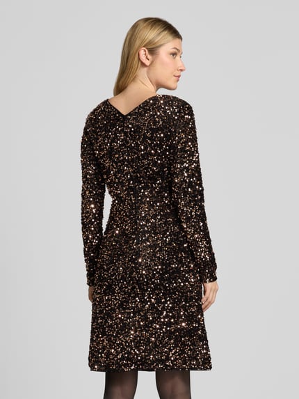 Frauenmodel trägt Knielanges Kleid mit Pailletten von Christian Berg Woman Selection in Schwarz und Gold, glitzernde Textur, Ganzkörperansicht Rückansicht.