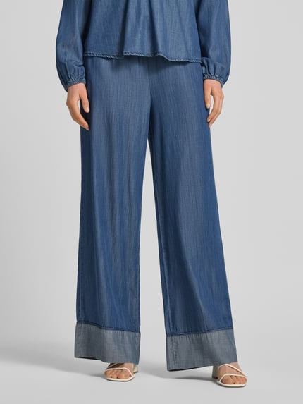 Frauenmodel trägt Loose Fit Jeans mit Viskose-Anteil Modell 'Wilke' von FREE/QUENT in mittelblau, elastischer Bund, fixierte Beinabschlüsse, Nahaufnahme Unterkörper.