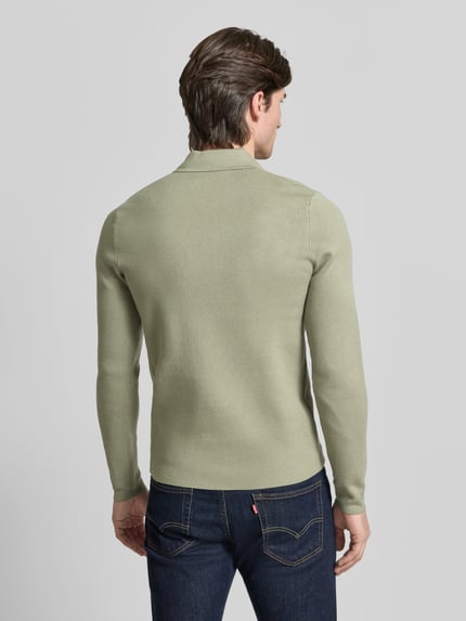 Männermodel trägt Slim Fit Pullover mit Polokragen Modell 'GUNA' von Samsøe Samsøe in hellem Grün, Rückenansicht, Ganzkörperansicht Rückansicht.