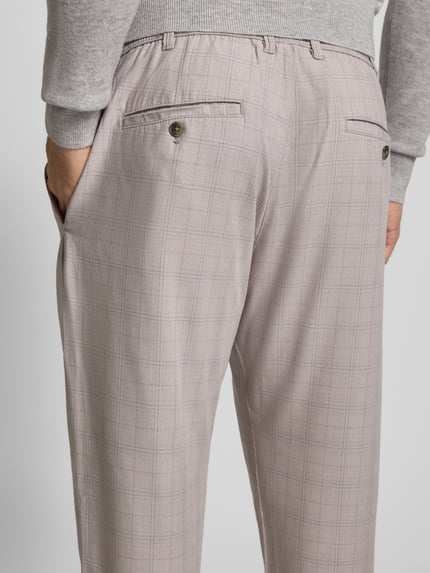 Männermodel trägt Stoffhose mit elastischem Bund von MCNEAL, graues Karo-Muster, Gesäßtaschen, Material-Mix, Ganzkörperansicht Rückansicht