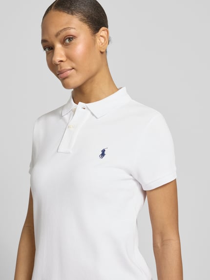 Frauenmodel trägt Straight Fit Polokleid aus reiner Baumwolle von Polo Ralph Lauren in Weiß, Piqué-Struktur, Logo-Stitching, Nahaufnahme Oberkörper.