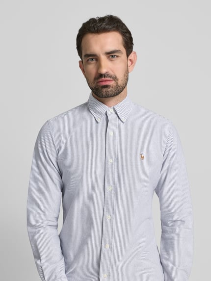 Männermodel trägt Freizeithemd mit Knopfleiste von Polo Ralph Lauren aus reiner Baumwolle, feine Streifen, Regular Fit, Nahaufnahme Oberkörper.