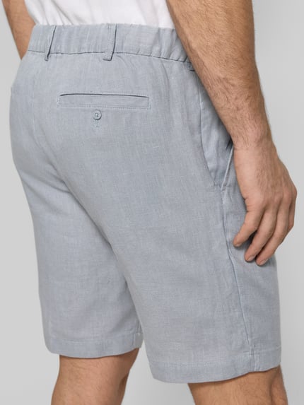 Männermodel trägt Bermudas aus reinem Leinen von JAKE*S STUDIO MEN in Hellgrau mit teilelastischem Bund, Eingriffstaschen, lockere Passform, Detailaufnahme von hinten.