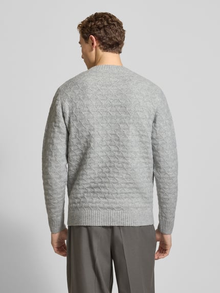 Męski model nosi szary Strickpullover mit gerippten Abschlüssen Modell 'BLASIMON' od Jack & Jones Premium, tekstura dzianiny, widok całej sylwetki z tyłu. Regularny krój, mieszanka materiałów z wełną, ściągacze.