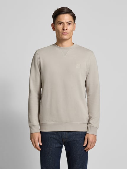 Męski model nosi Regular Fit Sweatshirt aus reiner Baumwolle Modell 'WESTART' od BOSS Orange, jednolity kolor, wyhaftowane logo, drobne prążkowanie, okrągły dekolt, długie rękawy, elastyczne zakończenia, bawełna, Ganzkörperansicht von vorne.