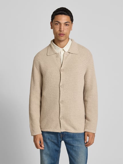 Männermodel trägt Cardigan aus katoenmix van closed in beige met structuurpatroon, platte kraag, doorlopende knoopsluiting, losse pasvorm, ruglengte maat M 70 cm, schouderbreedte 47 cm, mouwlengte 67 cm, ganzkörperansicht van voren.