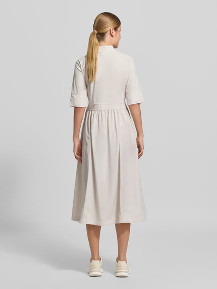 Frauenmodel trägt Midikleid mit Umlegekragen von Marc Cain in Offwhite, taillierte Passform, elastischer Material-Mix, Rückenansicht Ganzkörperansicht.