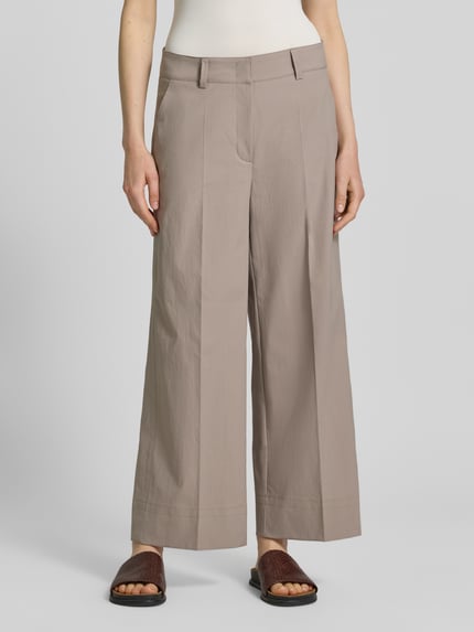Frauenmodel trägt Stoffhose mit Eingrifftaschen Modell 'CARA' von Cambio, beige, Wide Leg, Bügelfalte, Nahaufnahme Oberkörper