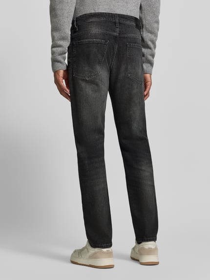 Männermodel trägt Regular Fit Straight Fit Jeans mit Label-Patch von BOSS Orange, dark wash Denim im Used Look, Ganzkörperansicht Rückansicht