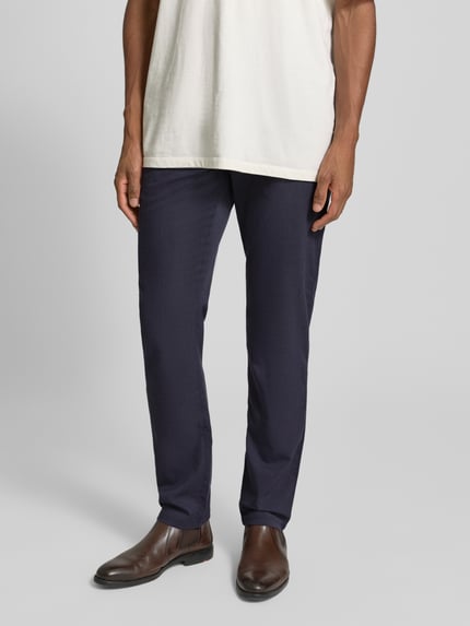 Mannelijk model draagt Slim Fit Stoffhose met viscose-aandeel van MCNEAL in donkerblauw, steekzakken, elastische stof, close-up onderlichaam, vooraanzicht.