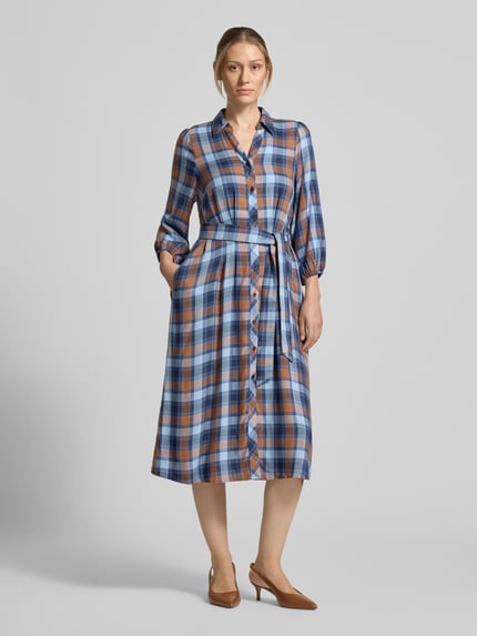 Frauenmodel trägt Midikleid aus reiner Viskose mit Umlegekragen von MORE & MORE, kariertes Muster, Knopfleiste, Taillenband, Ganzkörperansicht von vorne.