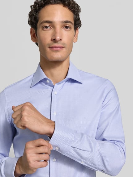 Männermodel trägt Slim Fit Businesshemd aus reiner Baumwolle von Seidensticker, hellblau mit feinem Muster, Nahaufnahme Oberkörper