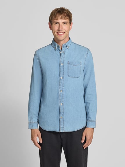 Männermodel trägt Regular Fit Jeanshemd mit Brusttasche Modell 'BROOK' von JACK & JONES in Hellblau, reine Baumwolle, Ganzkörperansicht von vorne.