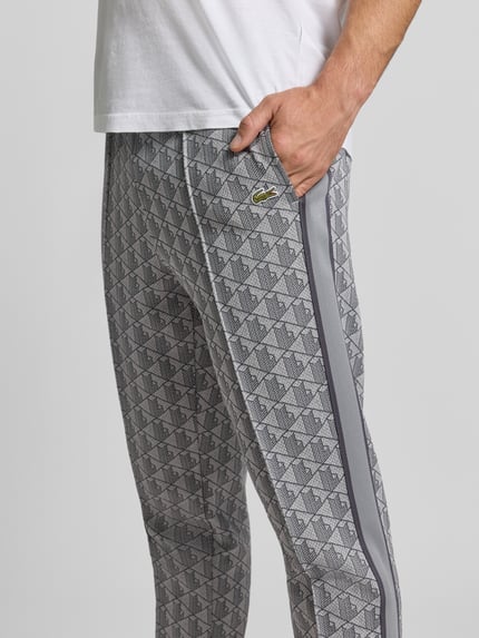 Männermodel trägt Regular Fit Sweathose mit Baumwoll-Anteil von Lacoste, graue Muster, glatte Textur, Nahaufnahme Oberkörper, Herren Sweathose von Lacoste.