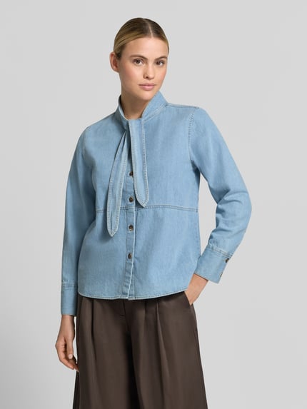 Frauenmodel trägt Regular Fit Hemdbluse aus reiner Baumwolle in Denim-Optik von Emily Van den Bergh, Stehkragen, langärmelig, Ganzkörperansicht von vorne.