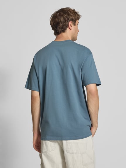 Männermodel trägt Herren T-Shirt mit Label-Stitching Modell 'Madison' von Carhartt Work In Progress, Reine Baumwolle, Regular-Fit, Farbe Blau, Rundhalsausschnitt, Rückenlänge bei Größe M 75 cm, Ganzkörperansicht Rückansicht.