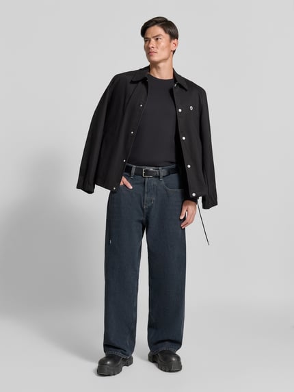 Männermodel trägt Relaxed Fit Jeans aus reiner Baumwolle von Diesel in Dunkelblau, 5-Pocket-Design, Knopf- und Reißverschluss, Ganzkörperansicht von vorne.