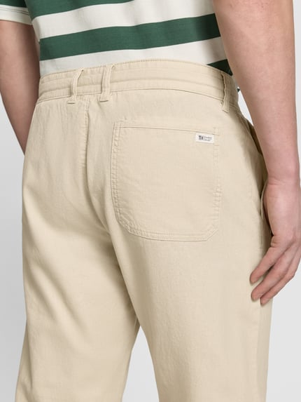 Männermodel trägt Relaxed Fit Hose aus Leinen-Baumwoll-Mix von s.Oliver RED LABEL, Optik: Unifarben, Label-Stitching, Detailaufnahme Rückansicht.