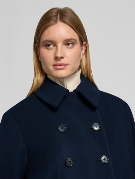Frauenmodel trägt Kurzmantel aus Wolle mit doppelter Knopfleiste von POLO RALPH LAUREN in Dunkelblau, sichtbare Struktur, Nahaufnahme Oberkörper.