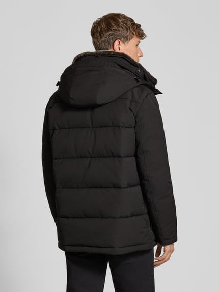 Männermodel trägt Steppjacke mit Kapuze Modell 'PIAZZA' von Strellson, unifarben, sichtbare Nähte, Pattentaschen, Ganzkörperansicht Rückansicht.