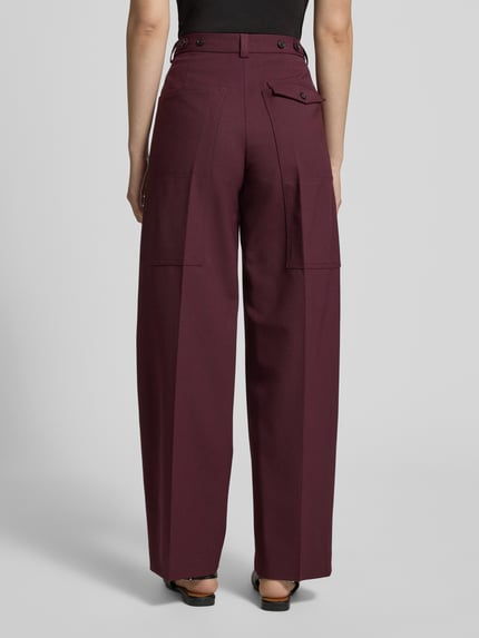Kobiece modelka nosi Loose Fit Weite Hose aus Woll-Mix od Tommy Hilfiger, efekt: jednolity kolor, kanty, szlufki na pasek, zapięcie na guzik i zamek błyskawiczny, wpuszczane kieszenie, mała kieszeń z patką z przodu, kieszeń z patką z tyłu, wykończenie materiału: splot twill, mieszanka wełny, widok całej sylwetki z tyłu.