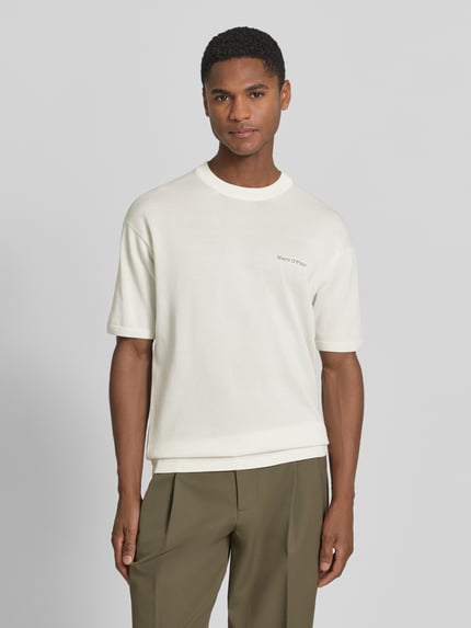 Männermodel trägt Regular Fit T-shirt uit puur katoen Marc O'Polo × DFB Travel Collection in effen kleuren met labelstitching en labelpatch, ronde hals, korte mouw, knitwear, Ganzkörperansicht van voren.