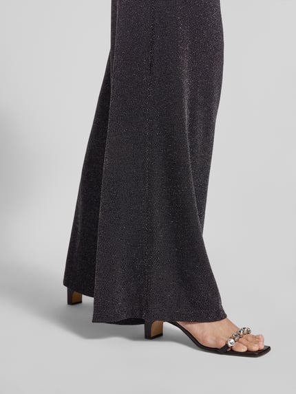 Frauenmodel trägt Stoffhose mit Glitter-Effekt von Christian Berg Woman, Material-Mix mit Stretch-Anteil, lockerer Schnitt, Detailaufnahme.