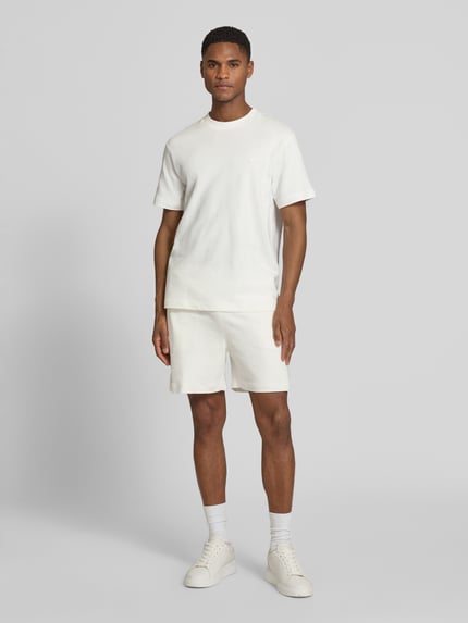 Männermodel trägt Regular Fit T-Shirt aus reiner Baumwolle von Lacoste, Optik: Unifarben, Label-Patch, Rundhals, Kurzarm, Feinstrick, Ganzkörperansicht von vorne.