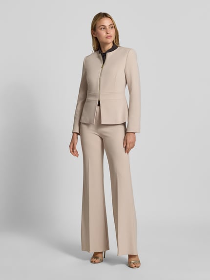 Frauenmodel trägt Kurzblazer mit Label-Detail von Rinascimento in Beige, taillierte Passform, Ganzkörperansicht von vorne.