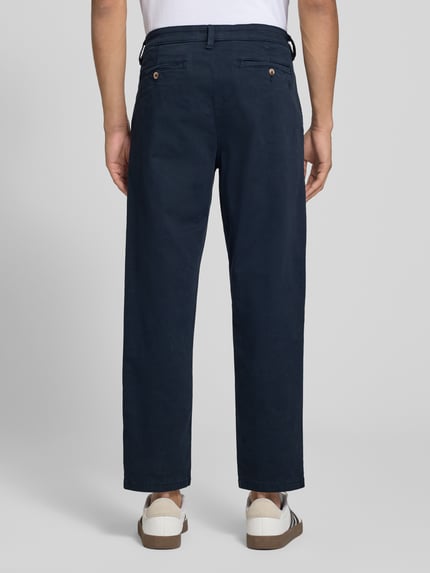 Mannenmodel draagt Straight Fit broek uit katoenmix van REVIEW in donkerblauw met achterzakken, bandwijdte maat M 42 cm, binnenbeenlengte 69 cm, volledige lichaam achteraanzicht.