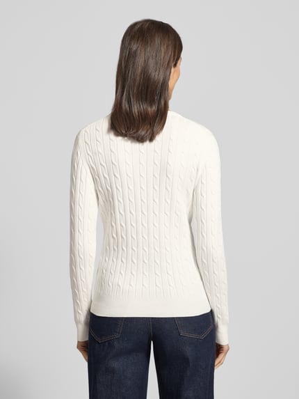 Modelka kobieca nosi biały Strickpullover mit Label-Detail od GANT, jednolity kolor, faktura w prążki, widok całej sylwetki z tyłu.