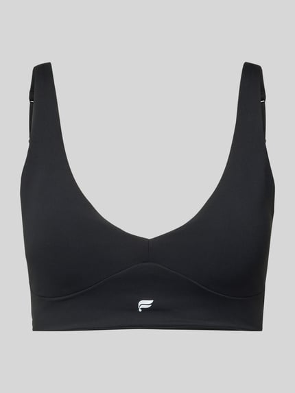 Produktfoto, czarny stanik z mieszanki elastycznych materiałów z nadrukiem z logo, krój dopasowany, model 'PURELUXE LONGLINE' od Fabletics, zapięcie na haftkę z tyłu, typ Low Impact Bra