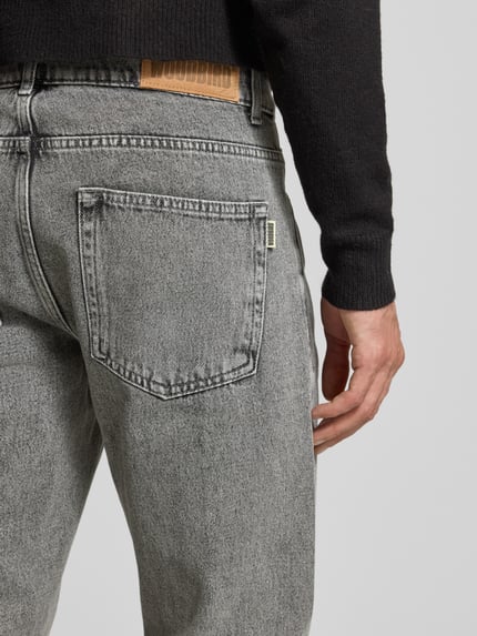 Männermodel trägt Jeans mit 5-Pocket-Design von WOODBIRD in Grau, reine Baumwolle, gerader Schnitt, Detailaufnahme Rückansicht.
