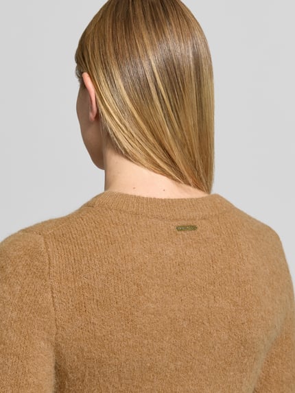 Frauenmodel trägt Slim Fit Strickpullover mit Rundhalsausschnitt von MICHAEL Michael Kors in Camel, gerippte Abschlüsse, Material-Mix mit Stretch-Anteil, Rückenlänge bei Größe S 53 cm, Ärmellänge 64 cm, Ganzkörperansicht Rückansicht.