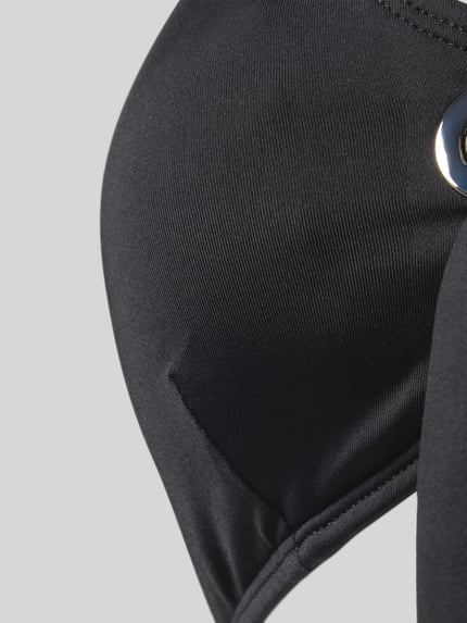 Frauenmodel trägt Damen Bikini-Top Modell 'GROMMET' von Michael Kors aus schwarzem Material-Mix mit Stretch-Anteil und Schnürung, Detailaufnahme.