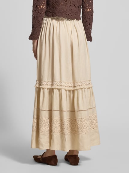 Vrouwenmodel draagt Ausgestellter Maxi-Rock aus reinem Leinen Modell 'PALLORE' van Weekend Max Mara in uni-look, regular fit, maxi-lengte met kanten applicatie, rechte zoom en zij-ingestoken zakken, beige kleur, textuur van puur linnen. Volledige lichaamsaanzicht achterkant.