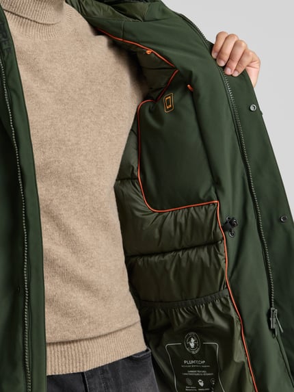 Männermodel trägt Jacke mit verdecktem Reißverschluss Modell 'WILSON' von Save The Duck in Dunkelgrün, Hochschließender Kragen, Nahaufnahme Oberkörper.