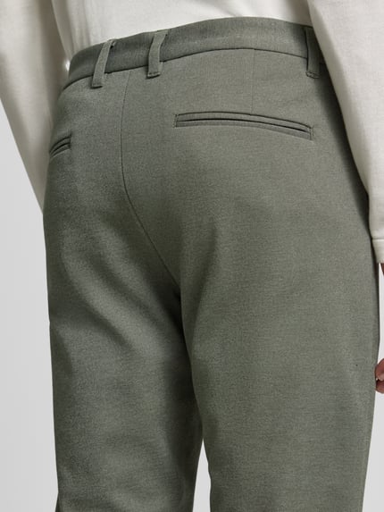 Männermodel trägt Slim Fit Stoffhose mit umgeschlagenen Hosenbeinen von Lindbergh in Grau, elastischer Viskose-Mix, Detailaufnahme, KI-modifiziertes Bild.