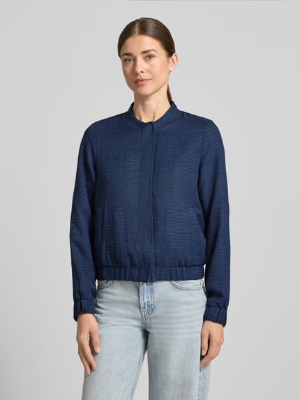 Vrouwenmodel draagt Regular Fit blouson met baseballkraag model 'MELANEY' van Vero Moda, mêlee look, zij-steekzakken, geribde zoom, drukknoopsluiting, lange mouw; vooraanzicht, bovenlichaam close-up.