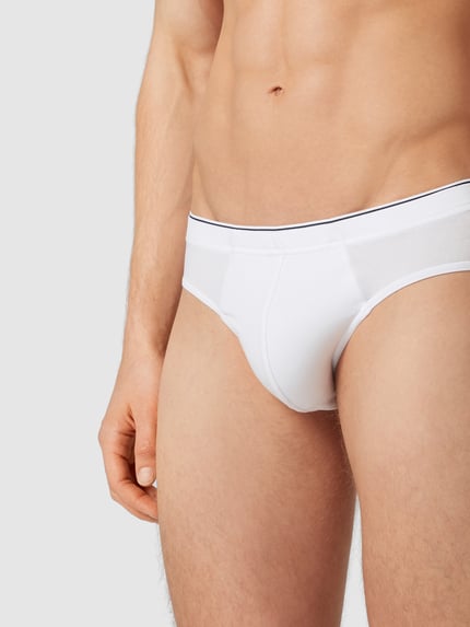 Męski model nosi Slip mit elastischem Bund im 3er-Pack od MCNEAL, biały, gładki materiał, bawełna z elastanem, ujęcie z przodu, zbliżenie na tułów.