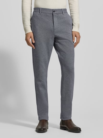 Männermodel trägt Relaxed Fit Schmale Hose aus reiner Baumwolle Modell 'HARLEM' von Tommy Hilfiger, Two-Tone, Optik: unifarben, Ganzkörperansicht von vorne.