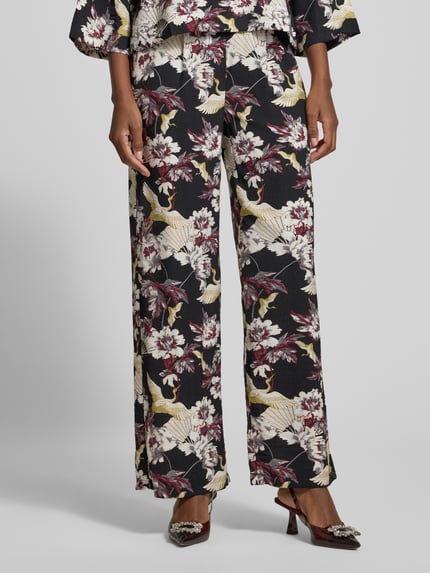 Vrouwenmodel draagt Stoffhose aus Viskose-Mix Modell 'Orelia' van GUIDO MARIA KRETSCHMER WOMAN met bloemenprint, wijde pijpen, zakken, allover-look, Nahaufnahme onderlichaam.