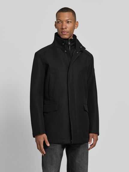 Männermodel trägt Kurzmantel Modell 'DARRY' von JOOP! in Schwarz mit Stehkragen, verdecktem Reißverschluss, Struktur, Ganzkörperansicht von vorne