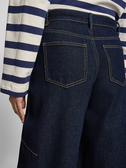 Vrouwenmodel draagt Barrel Jeans uit katoenmix model 'KAITLIN' van Vero Moda, melange denim met label-applicatie, detailopname rug.