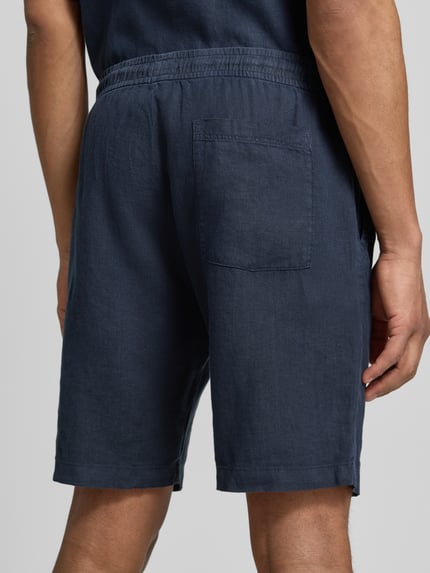 Männermodel trägt Shorts mit elastischem Bund und Gesäßtasche von MCNEAL in Dunkelblau, Reine Baumwolle, Regular-Fit, Ganzkörperansicht Rückansicht. Bundweite bei Größe M: 45 cm, Innenbeinlänge bei Größe M: 24 cm.