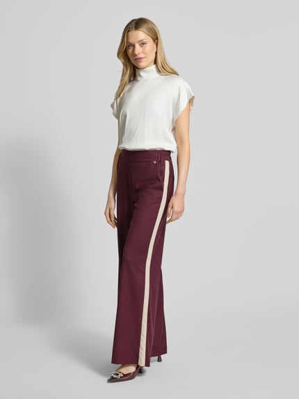 Frauenmodel trägt Stoffhose mit weitem Bein und elastischem Bund von Rinascimento, bordowy z beżowym pasem, Ganzkörperansicht von vorne.