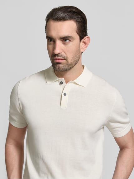 Männermodel trägt Regular Fit Poloshirt in Strick-Optik von Christian Berg Men in Creme, reine Baumwolle, Nahaufnahme Oberkörper.