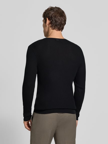 Männermodel trägt Strickpullover aus Lyocell-Woll-Mix mit Knopfleiste von Antony Morato, Slim Fit, Ripp-Optik, Ganzkörperansicht Rückansicht